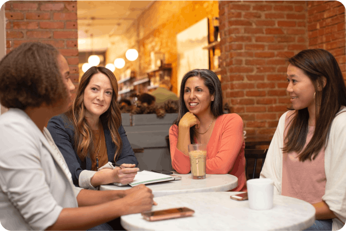 Four women sitting at a coffee table having a conversation