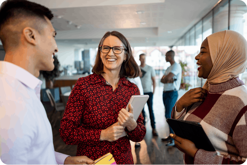 Three MongoDB employees talking and laughing in an office
